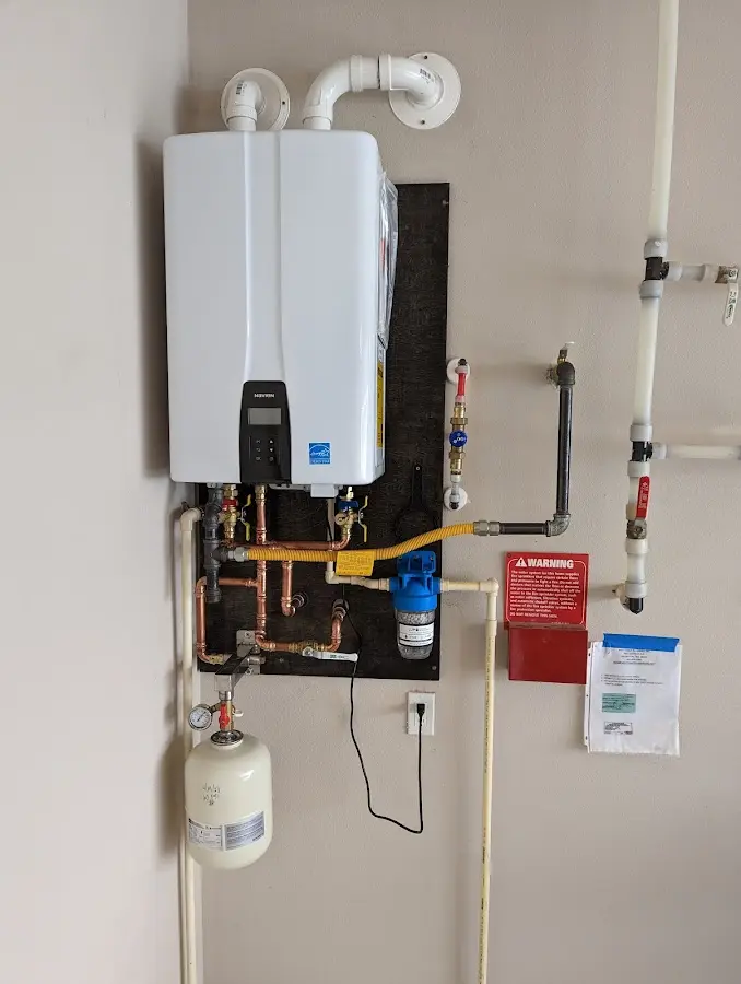 Professional plumber installing copper piping in a Hollis home